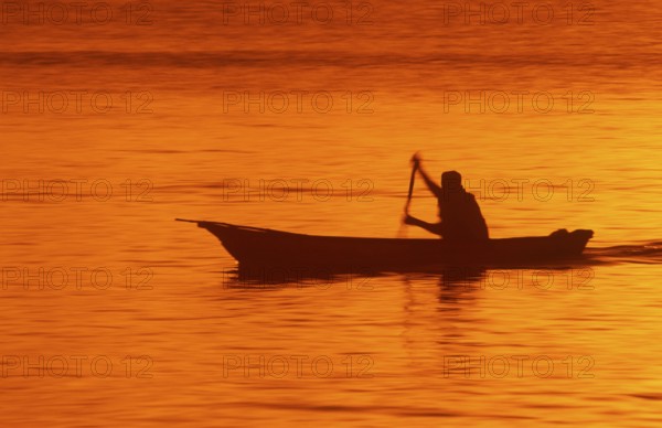 Silhouette of a fisherman in his boat at sunrise near Mikadi Beach, Dar es-Salaam, Tanzania, Africa, June 2000, vintage, retro, old, historic