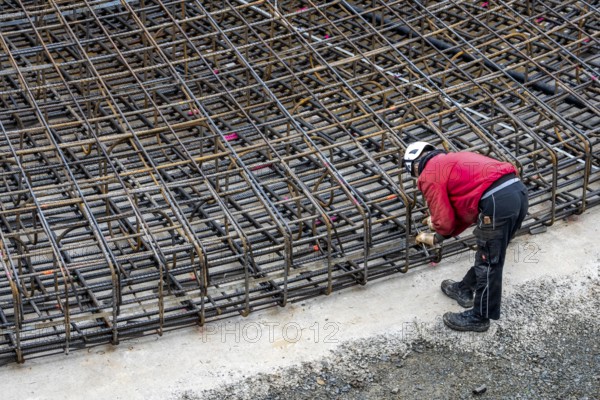 Assembly of reinforcing steel for the reinforced concrete foundation of a wind turbine, a mesh of rebar and reinforcing steel mesh, connecting the steel elements with binding wire, twisting with tongs, over 100 tons of reinforcing steel were used, the wind turbine will have a hub height of 160 meters, part of a new wind farm in Sauerland, near Balve, North Rhine-Westphalia, Germany