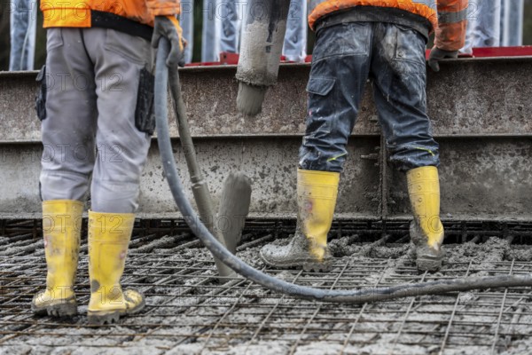 Concreting, concreting the foundation of a wind turbine, concrete pump hose, compressor, more than 600 cubic meters of concrete will be pumped into the foundation for over 7 hours, over 100 tons of reinforcing steel have been used, the wind turbine will have a hub height of 160 meters, part of a new wind farm in Sauerland, near Balve, North Rhine-Westphalia, Germany