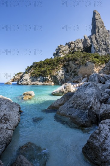 Light blue clear sea on a dream beach on Cala Goloritzé, picturesque rocky coast, steep coast with rock pin L'Aguglia, Golfo di Orosei, Baunei, Sardinia, Italy