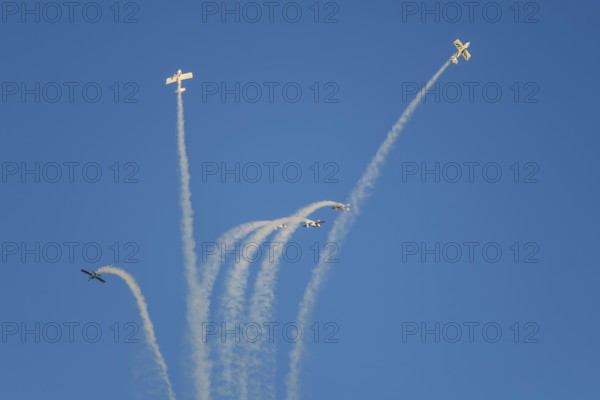 Stunt aerobatic planes performing stunts in blue sky with smoke trail. Concept of teamwork, collaboration, coordination, trust, precision, difficulty, challenge, speed, synergy