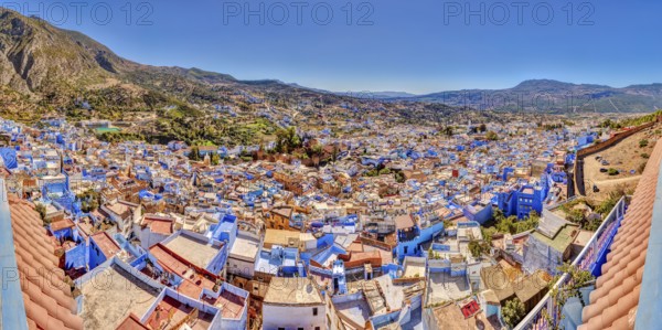 View of a city full of blue buildings with mountains in the background, Morocco, Chefchaouen, panorama