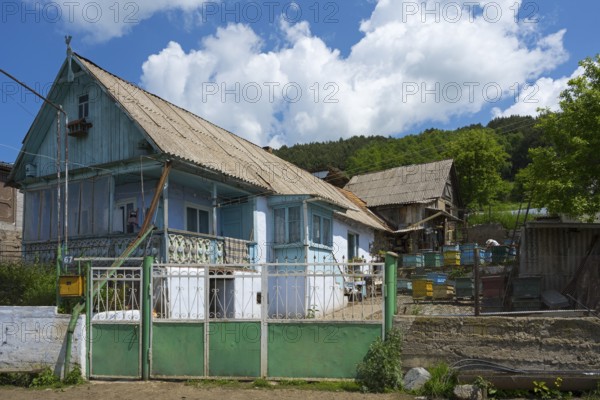 Rural scene with a blue house and several beehives in the foreground, surrounded by nature, Lermontovo, inhabited by spiritual Christians Pryguny and Molokans from Russia, Lorikeet province, Armenia