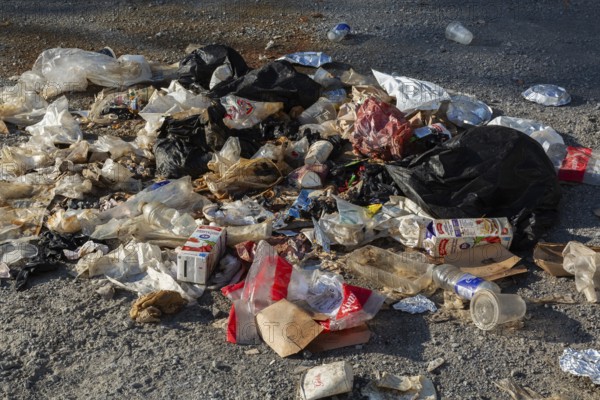 Recyclable plastic, paper and cardboard items discarded on the ground in public park, Quebec, Canada