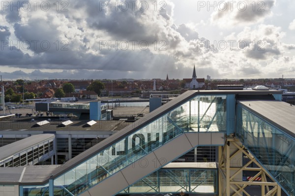 Ferry terminal, harbor with cityscape, St. Nicholas Church, dramatic cloudy sky, sunbeams, Rønne, Bornholm, Baltic Sea, Denmark