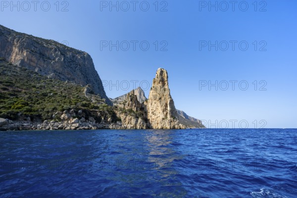 Picturesque rocky coast, cliffs with Pedra Longa pinnacle in the evening light, blue sea, Golfo di Orosei, Baunei, Sardinia, Italy