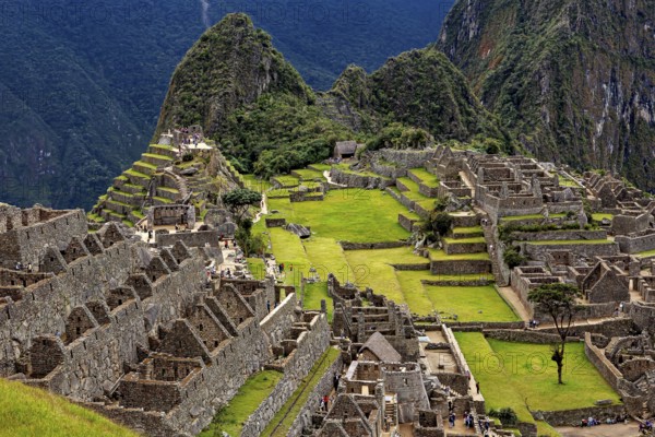 Ancient stone ruins and green terraces against a mountain backdrop, The ruins of the Inca city of Machu Picchu in Peru