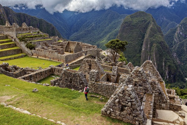 View of the extensive ruins of Machu Picchu surrounded by impressive mountain scenery, The ruins of the Inca city of Machu Picchu in Peru