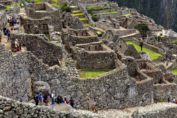 Tourists explore the well-preserved stone ruins of Machu Picchu, the ruins of the Inca city of Machu Picchu in Peru