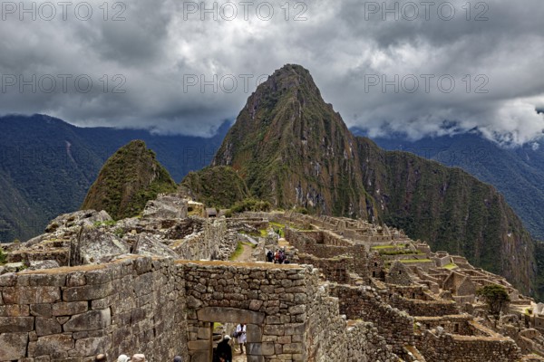 Machu Picchu with dramatic cloudscape and visible mountain, The ruins of the Inca city of Machu Picchu in Peru