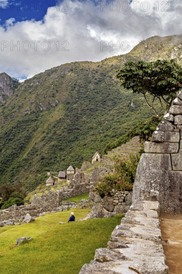 Stone terraces of Machu Picchu with surrounding green hills and blue sky, The ruins of the Inca city of Machu Picchu in Peru