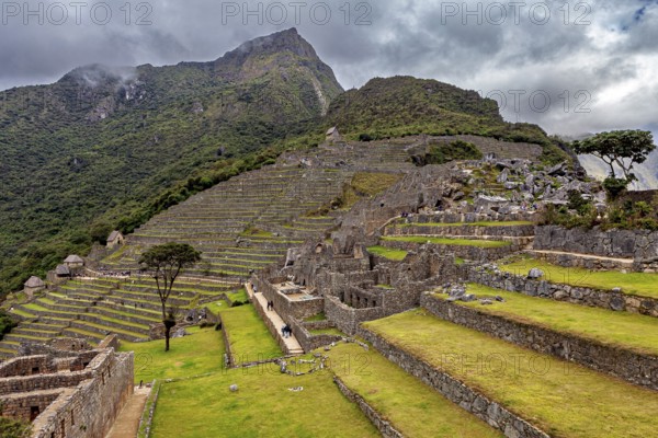 Nested Inca terraces and walls in front of picturesque mountains in Machu Picchu, The ruins of the Inca city of Machu Picchu in Peru
