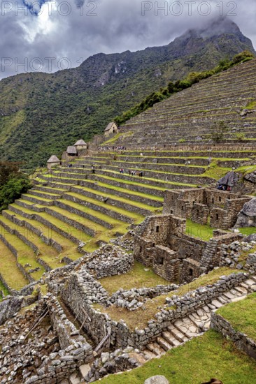 Impressive Inca ruins with terraces on a misty mountainside in Peru, surrounded by green nature and clouds, The ruins of the Inca city of Machu Picchu in Peru