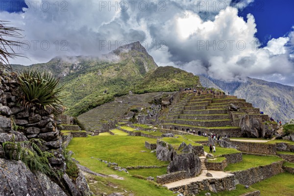 Inca terrace landscape under dramatic sky with clouds and mountain peaks near Machu Picchu, The ruins of the Inca city of Machu Picchu in Peru