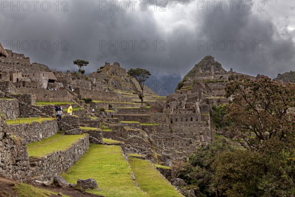 Painting the ruins of Machu Picchu under ominous skies and dramatic mountain scenery, The ruins of the Inca city of Machu Picchu in Peru