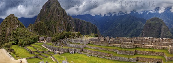 Panorama of Machu Picchu with mountains in the background and thick cloud sky, The ruins of the Inca city of Machu Picchu in Peru