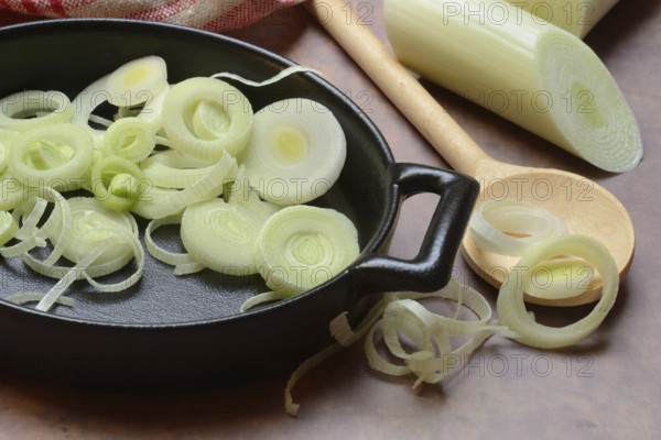 Leeks, leek rings in pan with cooking spoon, leek