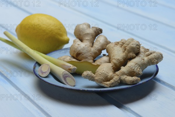 Ginger tubers with lemongrass on plate, lemon