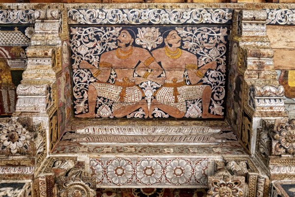Ornate wall painting with two symmetrical warrior figures in a traditional temple, the decoration inside the Temple of the Tooth of Kandy Sri Lanka