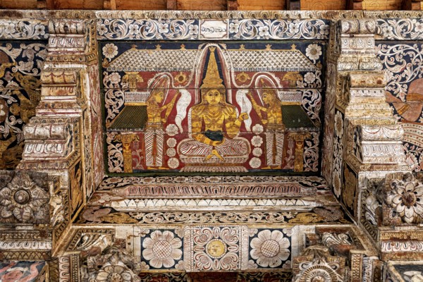 Detailed wall painting of a Buddha in a magnificent, decorative temple interior, the decoration inside the Temple of the Tooth of Kandy Sri Lanka