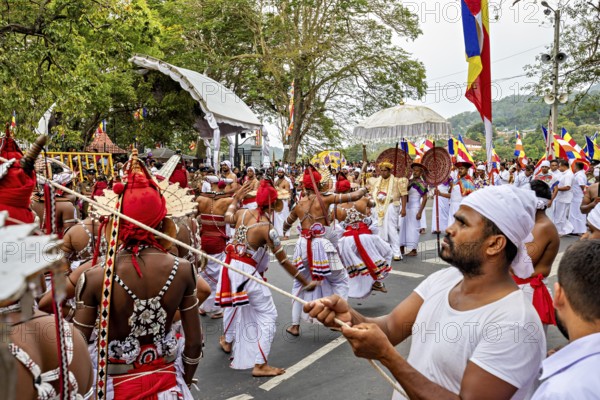 Dancers in moving costumes with flags and drums at a street festival, The Perahera Parade in Kandy Sri Lanka
