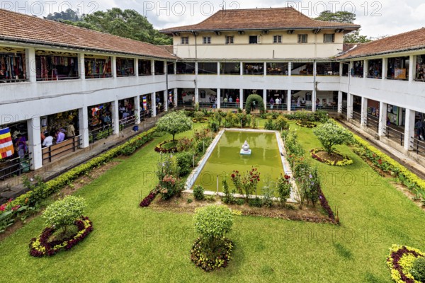 A well-kept courtyard with a central fountain and surrounding flower beds in a historic building, The Market Halls of Kandy Sri Lanka