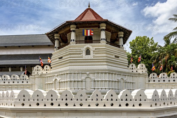Detail of a temple with pavilion, colorful flags and white walls, The Temple of the Tooth in Kandy Sri Lanka
