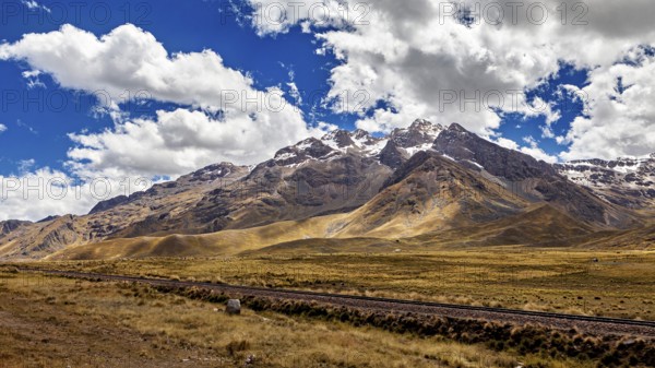 Impressive mountain range with snowy peaks under a cloudy blue sky, the landscape in the highlands of Peru