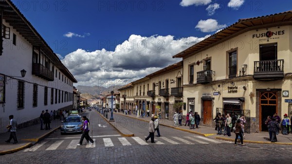 Busy street in a city with colonial architecture under a cloudy sky, The streets of Cusco in Peru
