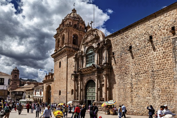Church façade on a busy town square with moving shadows and dramatic skies, The churches of Cusco in Peru