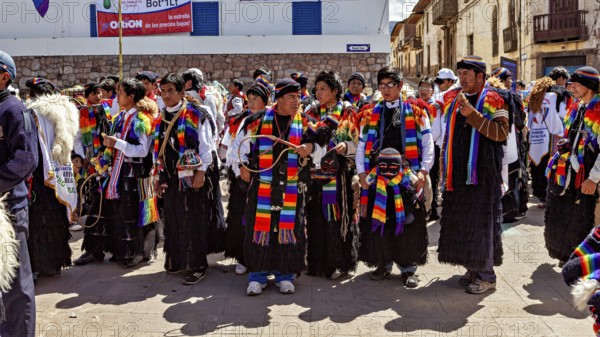 People wearing traditional clothes wearing colorful scarves take part in a street parade, traditional parade of festival groups in Cusco in Peru