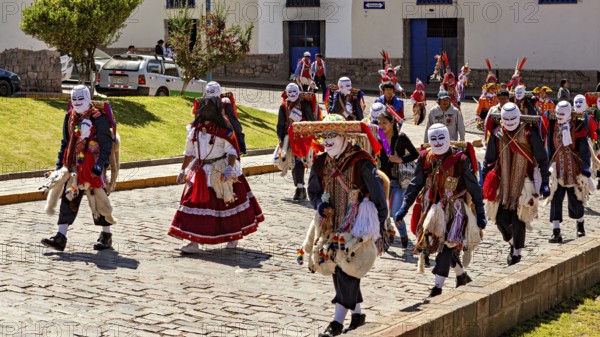 Group of people wearing masks and traditional garments at a parade, Traditional procession of festival groups in Cusco in Peru
