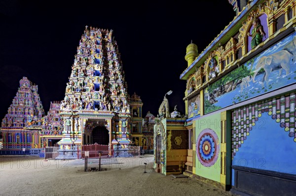 Colourfully illuminated temple complex with complex architecture and wall paintings at night, The Sri Pathrakali Amman Trincomalee in Sri Lanka