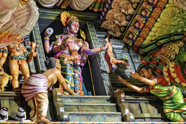 Complex sculpture scene with figures depicting rituals in traditional temple colors, The Sri Pathrakali Amman Trincomalee in Sri Lanka