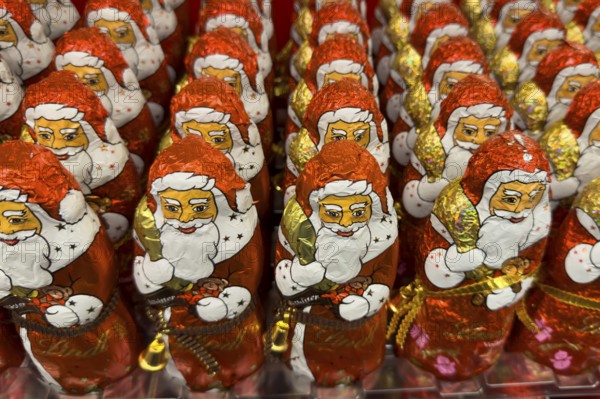 Display on the shelf of chocolate Santa Claus chocolate Santa Claus Santa Claus Santa Claus Santa Claus chocolate Santa Claus chocolate Santa Claus chocolate lice Santa Claus chocolate lice Santa Claus in color red of red staniol paper made of chocolate arranged like army of Santa Claus, Germany