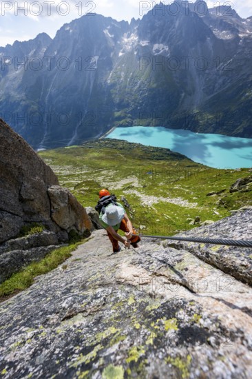 Mountaineer climbs on the secured Schijen-Zwärg via ferrata, climb to Bergseehütte, Göscheneralp in the back, Canton of Uri, Switzerland
