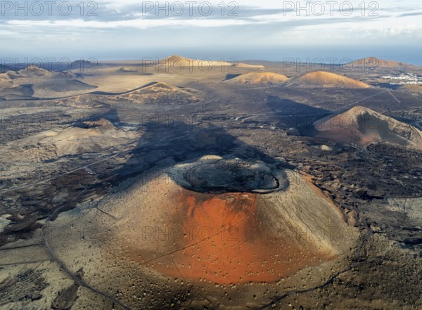 Caldera Colorada volcano, picturesque volcanic landscape with volcanic craters and lava fields in morning light, Parque Natural de Los Volcanes, aerial view, Lanzarote, Canary Islands, Spain