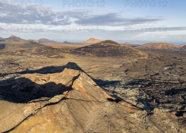 Volcán de Las Nueces volcano, picturesque volcanic landscape with volcanic craters and lava fields in morning light, Parque Natural de Los Volcanes, aerial view, Lanzarote, Canary Islands, Spain