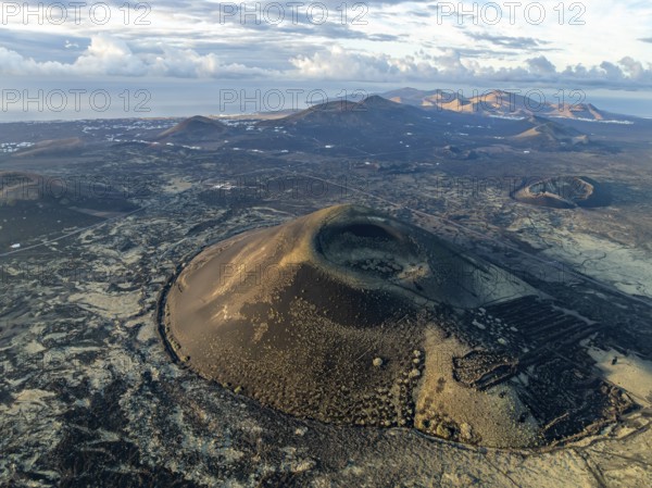 Montaña Negra volcano, picturesque volcanic landscape with volcanic craters and lava fields in morning light, Parque Natural de Los Volcanes, aerial view, Lanzarote, Canary Islands, Spain