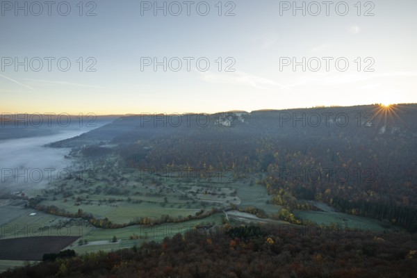 Sunrise with fog in the Neidlinger Valley with a view of the Reussenstein castle ruins. Swabian Jura, Baden-Württemberg, Germany