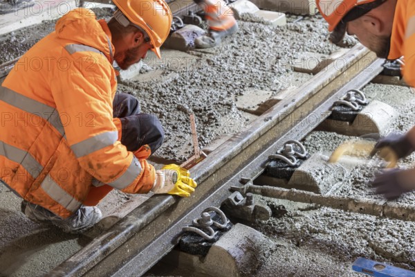 Deutsche Bahn AG track construction at Stuttgart Airport. The last few meters of solid road in the airport tunnel are concreted. This means that all long-distance railway tracks of Project S21 have been laid. Workers lay the rails and concrete the track bed. Stuttgart, Baden-Württemberg, Germany