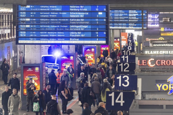 Travelers at the main train station, passengers and departure board at Stuttgart main station. Police vehicle with flashing lights. Stuttgart, Baden-Württemberg, Germany