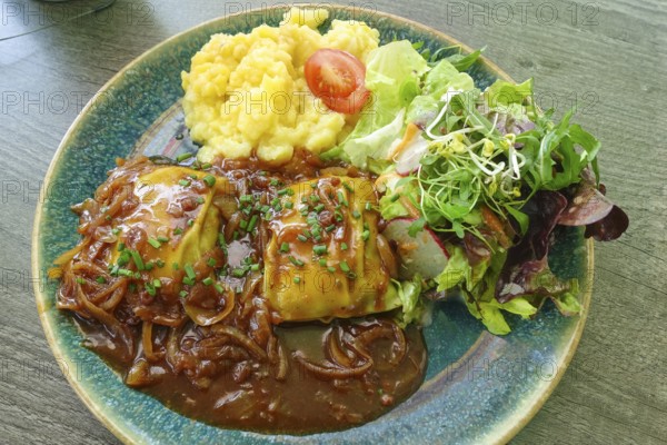Swabian cuisine, ravioli with potato salad, gravy with onions, colorful salad, mixed salad side dish, main course served on plate, grandmother's cuisine, regional, home cooking, typical Swabian, traditional cuisine, food photography, Germany