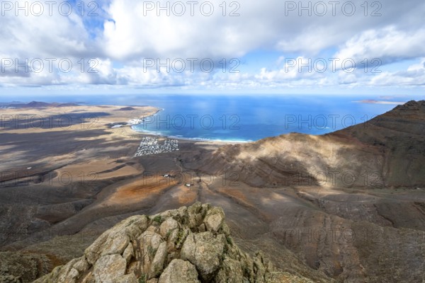View from the Risco de Famara cliffs to the coast and the sea with the Famara beach, Playa de Famara, Lanzarote, Canary Islands, Spain