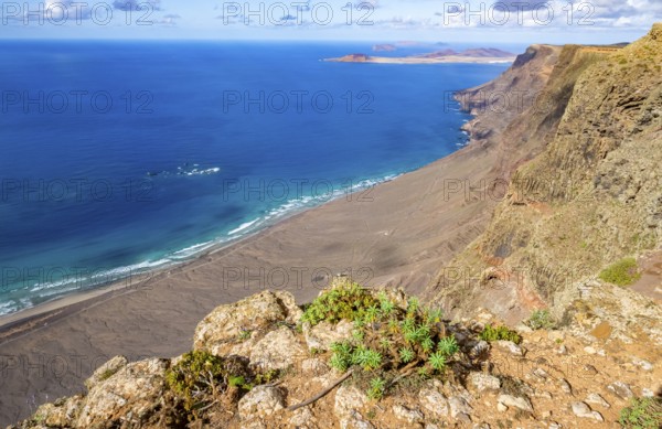 View from the Castillejo viewpoint from the Risco de Famara cliffs to the coast and the sea with the Famara beach, Playa de Famara, Lanzarote, Canary Islands, Spain