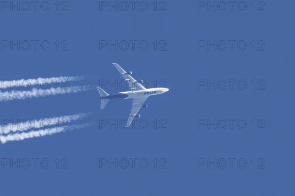 Boeing 747 jumbo jet cargo aircraft of Atlas air airlines flying in a blue sky with contrails or vapour trails behind, England, United Kingdom