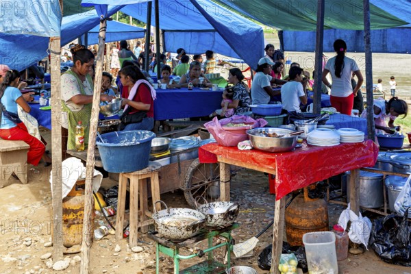 Market kitchen with people cooking and preparing food under blue tents, The market of Rurrenabaque in the Amazon jungle rainforest in Bolivia