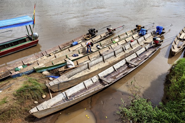 Person on wooden longboats on the banks of a quiet river, longboat on a river near Rurrenabaque in the Amazon jungle in Bolivia