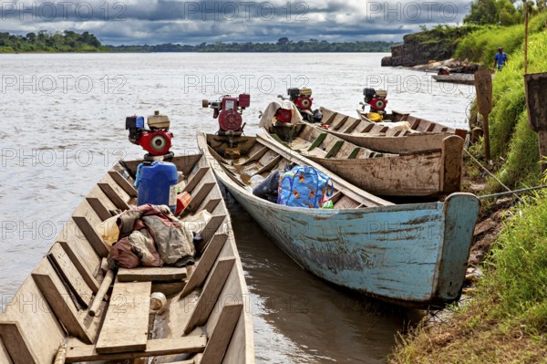 Wooden boats with motors on the river under cloudy sky, longboat on a river near Rurrenabaque in the Amazon jungle in Bolivia
