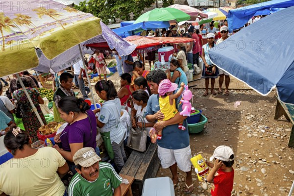 Lively market with lots of people, colorful umbrellas and a variety of goods, The Rurrenabaque market in the Amazon jungle rainforest in Bolivia